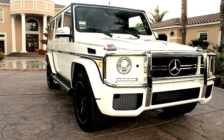 White Mercedes-Benz G Class Infront of a Mansion